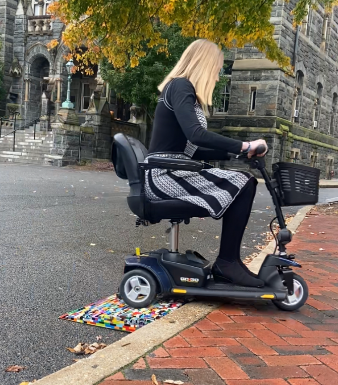 In the Healy Lawn circle, someone is using the lego ramp with a mobility scooter to get onto the circle where there are benches.